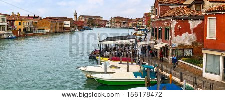 Venice, Italy - November 11, 2014: Venice panoramic skyline with old buildings, trattoria, people walking and boats docked