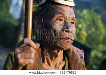 SINGHA CHINGNYU, NAGALAND/INDIA - DECEMBER 8, 2013: Tattooed face of elderly former Singha Chingnyu Village Headhunter. Naga tribes practised headhunting & preserved the heads of enemies as trophies.