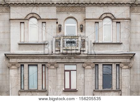 Several windows in a row and balcony on facade of the urban apartment building front view St. Petersburg Russia