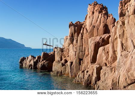 Arbatax, Sardinia, Italy, july 18 - 2016 diving from red rocks