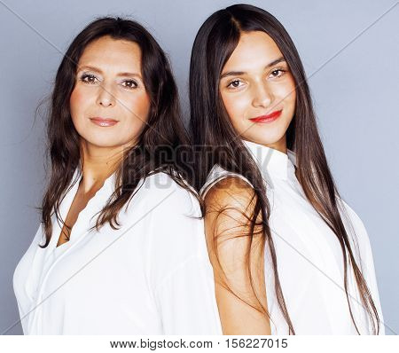 cute pretty teen daughter with mature mother hugging, fashion style brunette makeup close up, real happy family