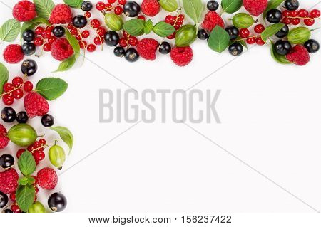 Various fresh summer berries. Ripe raspberries currants gooseberries mint and basil leaves. Berries on white background.