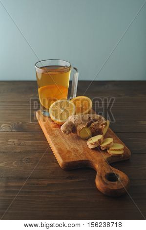 Black tea with lemon and ginger on wooden table