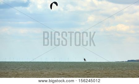 Athletic man jumping on kite surf board on a sea waves.