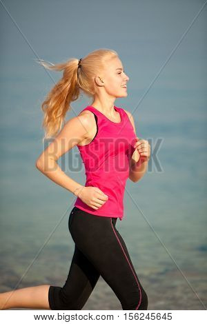 jogging in th beach - woman runns near sea on early summer morning