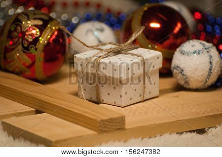 Gift in a little box is amound the Christmas decorations.