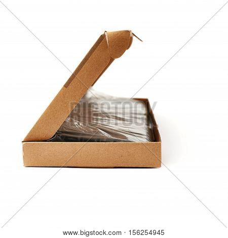 Black computer querty keyboard packed into cardboard box isolated over white background