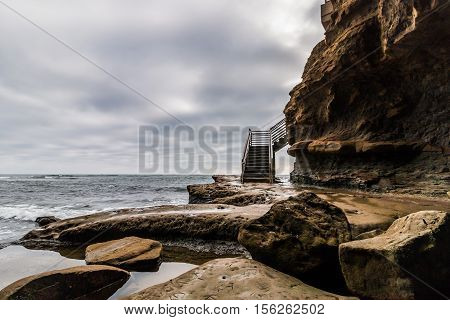 Surfer stairway access to ocean on a stormy day at Sunset Cliffs in San Diego, California.