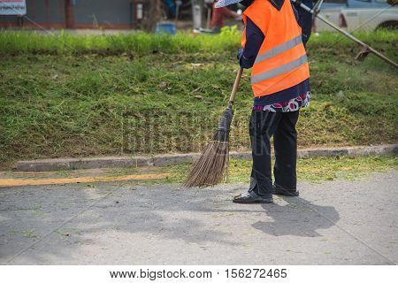 Road sweeper worker cleaning city street with broom tool in Thailand