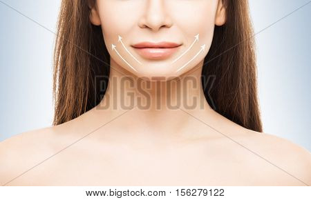 Close-up half face portrait of young, attractive woman with arrows on her face. Face lifting concept.