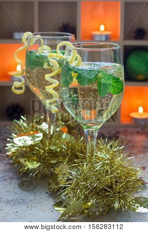 Spritzer cocktail with white wine mint and ice decorated with spiral lemon zest vertical