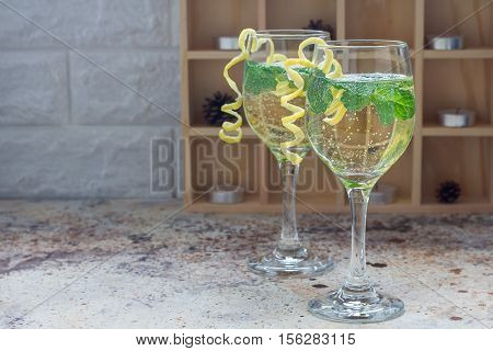 Spritzer cocktail with white wine mint and ice decorated with spiral lemon zest horizontal copy space