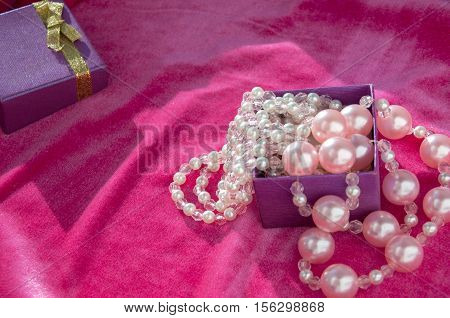 In crimson velvet box is pink with pearl beads