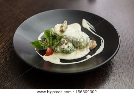 stuffed cabbage in a creamy sauce with basil and tomatoes