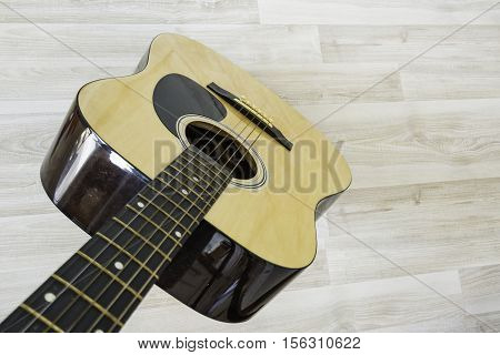 Acoustic guitar on a light wooden background
