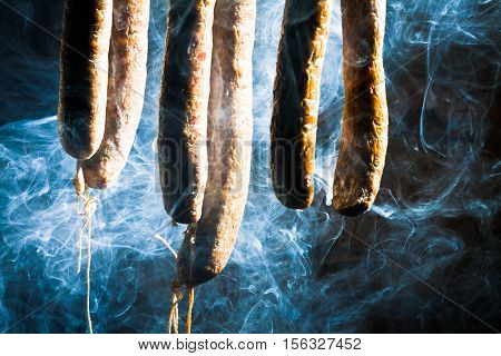 Smoked homemade sausage in forester's lodge on black background