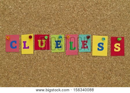 Clueless word written on colorful sticky notes pinned on cork board.