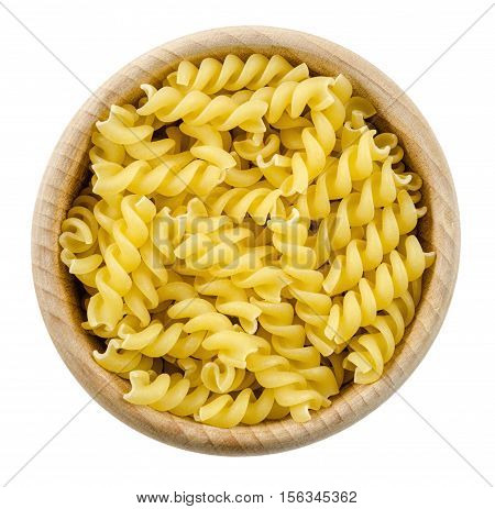 A portion of Rotini corkscrew pasta in wooden bowl. Uncooked dried durum wheat semolina pasta. Isolated on white background