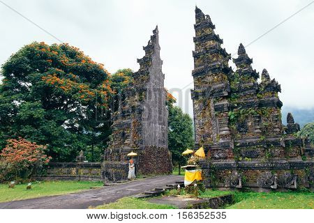 Traditional Balinese Hindu gate at rainy summer day with clouds - Candi Bentar, Bedugul in Bali island, typical Indonesia landscape.