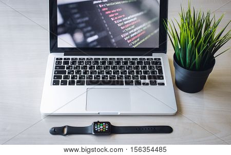 Modern design concept of creative workplace, smart watch, laptop, tablet, flower