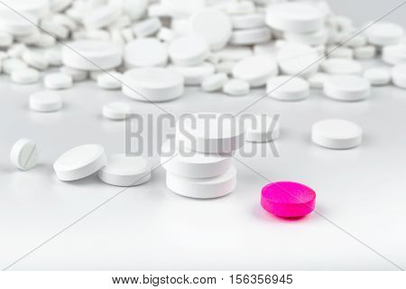Bunch Of White Tablets. Scattered Pills. Single Pink Pill