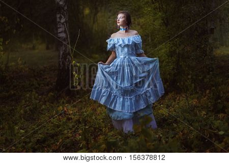 Girl in vintage dress in the forest at night.