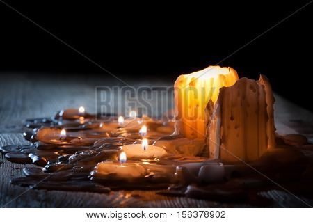 Candls with golden fire on shelf on black background