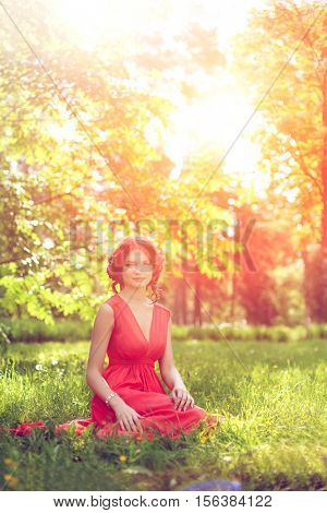 Beautiful girl on the nature in the park. Against the background of the summer lanshaft. Young romantic woman in the sunshine, sunset.