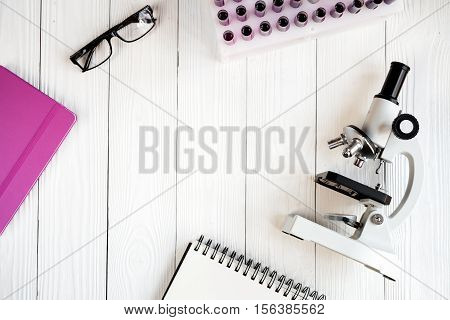 doctor workplace at wooden table with microscope in lab top view no one