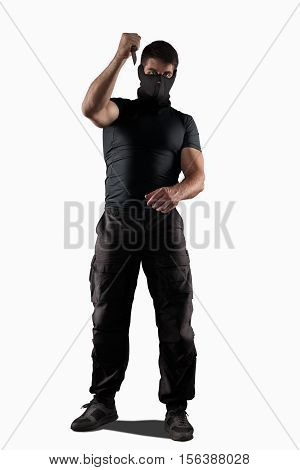 Man in black uniform attacking with knife isolated on white