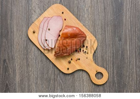 Appetizing bacon sliced on cutting board on wooden table
