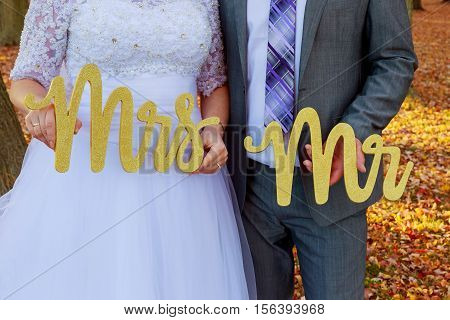 bride and groom holding Mr Mrs the bride and groom with the words Mr. and Mrs.