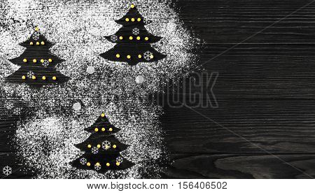 Cristmas card. On dark wooden background Christmas tree made of icing sugar flour. White Christmas Forest firs. Top view blank space