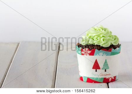 Chocolate Christmas Cupcake with Green Frosting on Light Background Horizontal