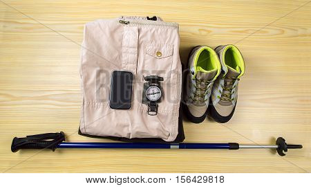 shot of various tools and equipment and telephone for a hiker laid out on a table