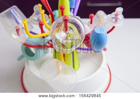 Baby drainer full of plastic tableware objects as baby bottles nasal aspirator milk bowls teats and others