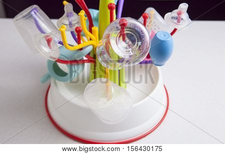 Baby drainer full of plastic tableware objects as baby bottles nasal aspirator milk bowls teats and others