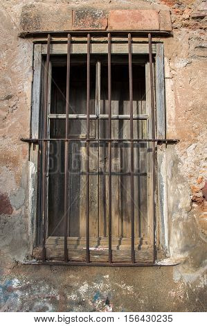cropped shot near a ancient window with bars