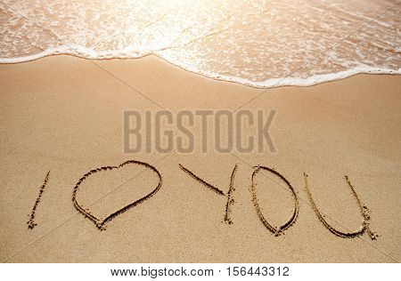 Love message written on the sand beach near sea
