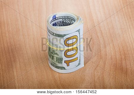 hundred-dollar bills rolled up with a rubber band