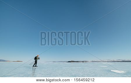 Tourists travel to Norway hiking ice skating on the frozen lake. Special long skate for long distances. Mounting under the ski boots. Location of Lake Baikal action. The Russian called Bayes or Loft.