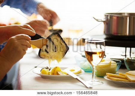 Traditional Swiss winter meal. Raclette. Melted cheese.