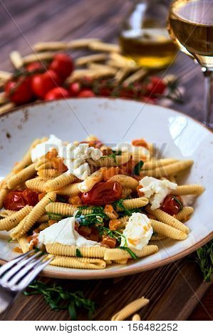 Vegetarian pasta garnished with tomato cheese and fresh herbs