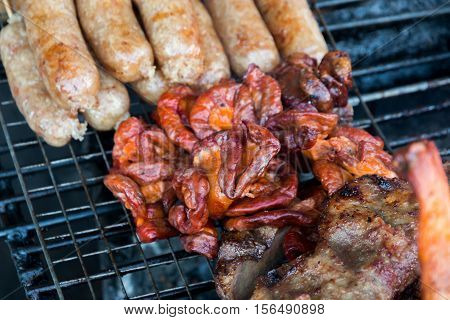 Grill chitterlings on stove. made from pork and salty sauce on burnt stove. In local market of thailand. street food