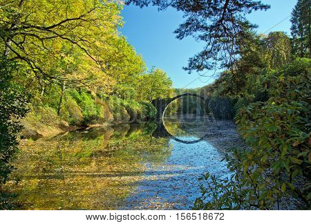 Arch Bridge in Kromlau, Saxony, Germany. Autumn in Park. Rakotz bridge in Kromlau