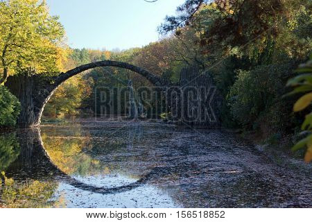 Arch Bridge in Kromlau, Saxony, Germany. Autumn in Park. Rakotz bridge in Kromlau