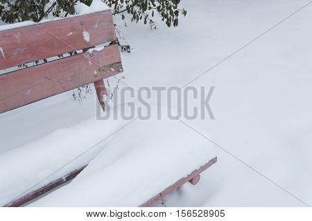 old bench with faded colors in snow