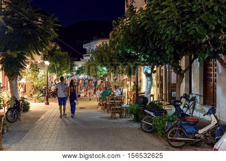 PALEOCHORA, CRETE, GREECE - JUNE 2016: People walking at night street of Paleochora town on Crete island, Greece