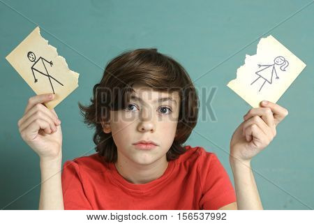 sad preteen boy unhappy about parents divorce hold man and woman paper drawing torn apart