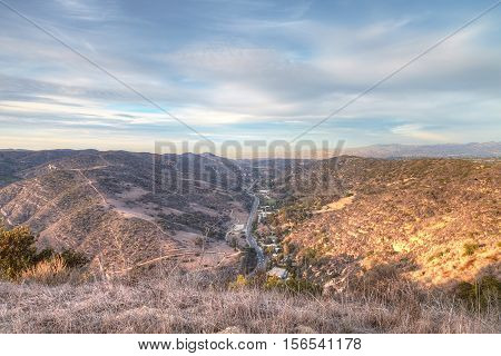 Laguna Canyon Road with Saddleback Mountains in the distance from Top of the World hiking trail in Laguna Beach at sunset